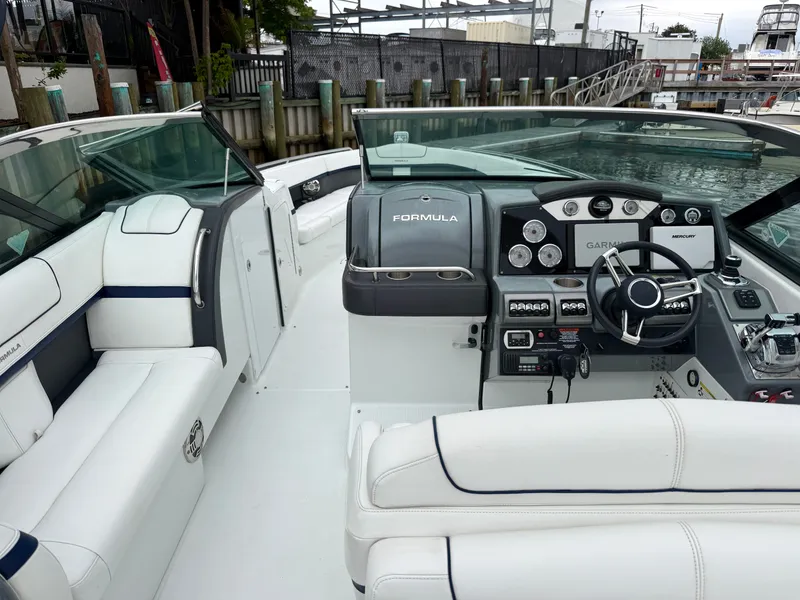 Slide: The Image of The image shows the cockpit of a 2014 Formula 350 Crossover Bowrider with white leather seating and modern electronics. - 12
