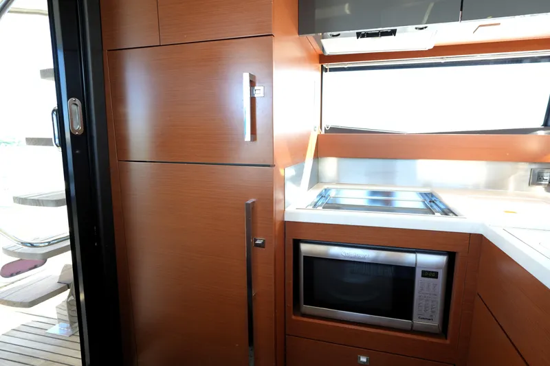 Slide: The Image of Modern kitchen area in a 2013 Prestige 500 yacht, featuring wood cabinetry and stainless steel appliances. - 52