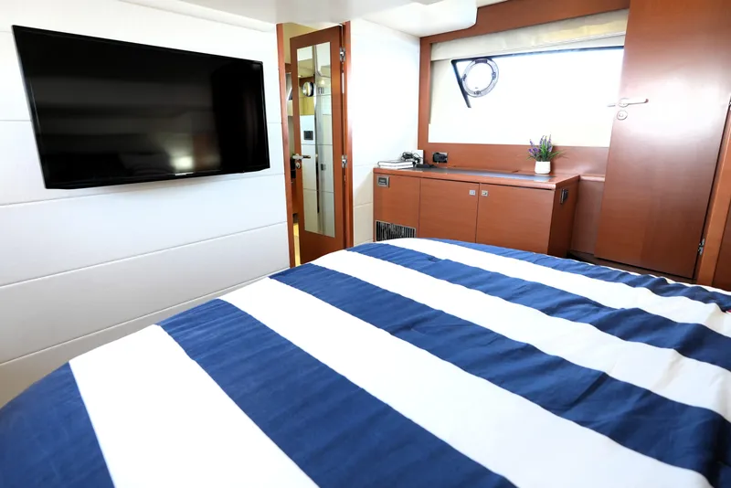 Slide: The Image of Luxurious cabin interior of 2013 Prestige 500 yacht with striped bedding and wall-mounted TV. - 83