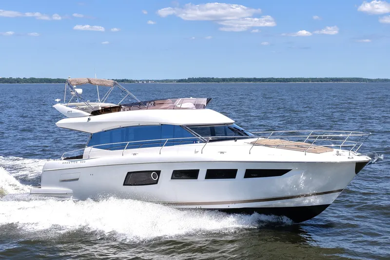 Slide: The Image of 2013 Prestige 500 yacht cruising on open water under a clear blue sky. - 17