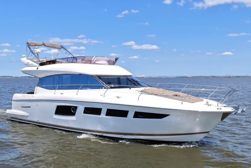 Slide: The Image of 2013 Prestige 500 yacht cruising on open water under a clear blue sky. - 10