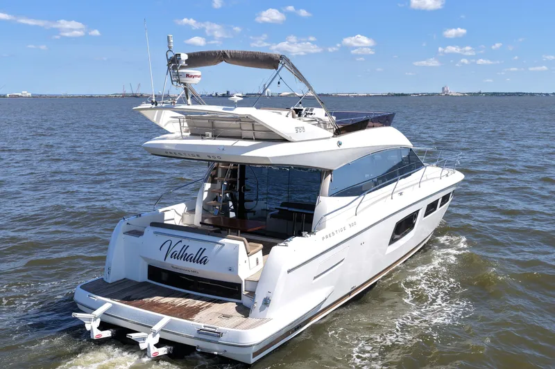 Slide: The Image of 2013 Prestige 500 yacht "Valhalla" cruising on open water under a clear blue sky. - 6