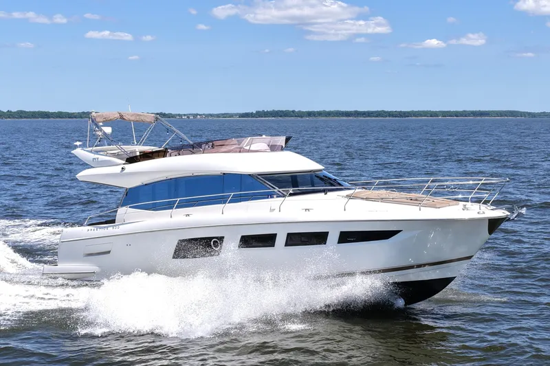 Slide: The Image of 2013 Prestige 500 yacht cruising on open water under a clear blue sky. - 18