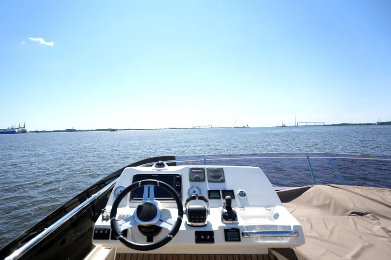 Slide: The Image of Helm of 2013 Prestige 500 yacht overlooking calm waters under clear blue sky. - 32