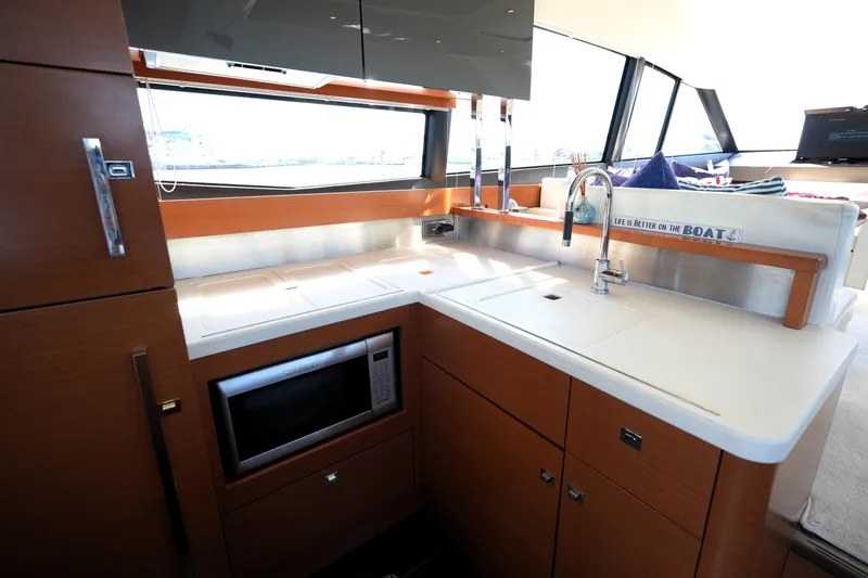 Slide: The Image of Modern kitchen interior on a 2013 Prestige 500 yacht, featuring sleek cabinetry and appliances. - 49