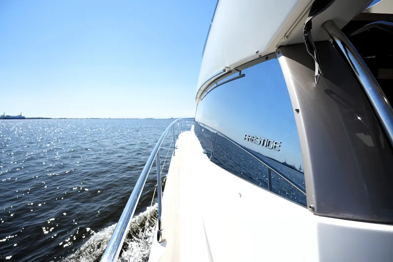 Slide: The Image of 2013 Prestige 500 yacht cruising on a sunny day, reflecting on calm waters. - 35