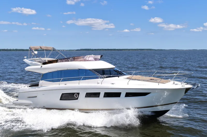Slide: The Image of 2013 Prestige 500 yacht cruising on open water under a clear blue sky. - 0