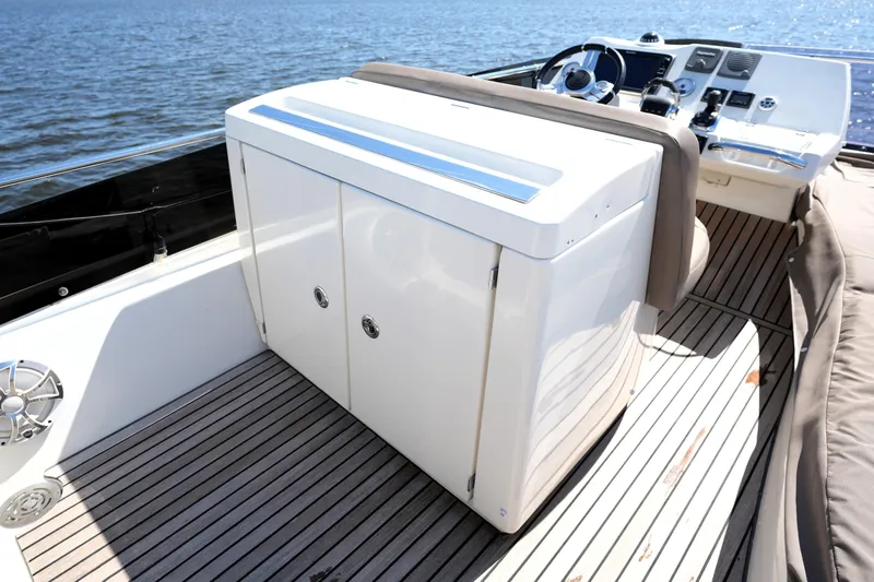 Slide: The Image of 2013 Prestige 500 yacht deck with helm and storage cabinet, overlooking the water. - 30