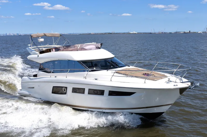 Slide: The Image of 2013 Prestige 500 yacht cruising on open water under a clear blue sky. - 15