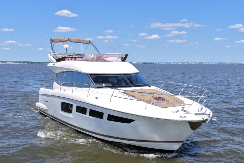 Slide: The Image of 2013 Prestige 500 yacht cruising on open water under a clear blue sky. - 12