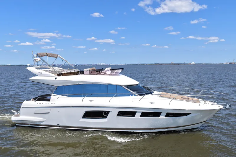Slide: The Image of Luxury 2013 Prestige 500 yacht cruising on open water under a clear blue sky. - 14