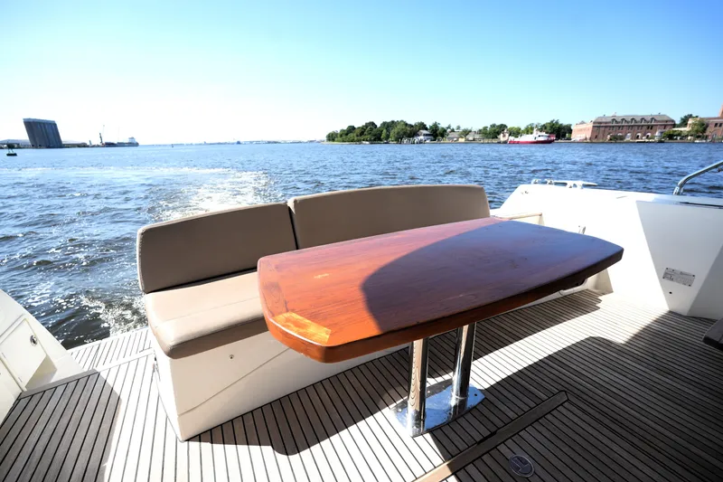 Slide: The Image of Luxury 2013 Prestige 500 yacht with elegant deck seating and wooden table, cruising on open water. - 23
