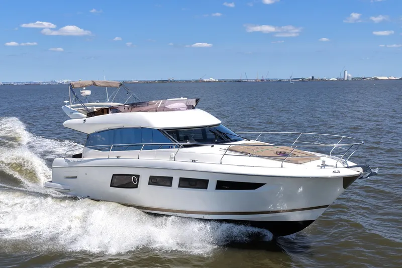 Slide: The Image of 2013 Prestige 500 yacht cruising on open water under a clear blue sky. - 16