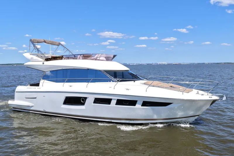 Slide: The Image of Luxury 2013 Prestige 500 yacht cruising on open water under a clear blue sky. - 8