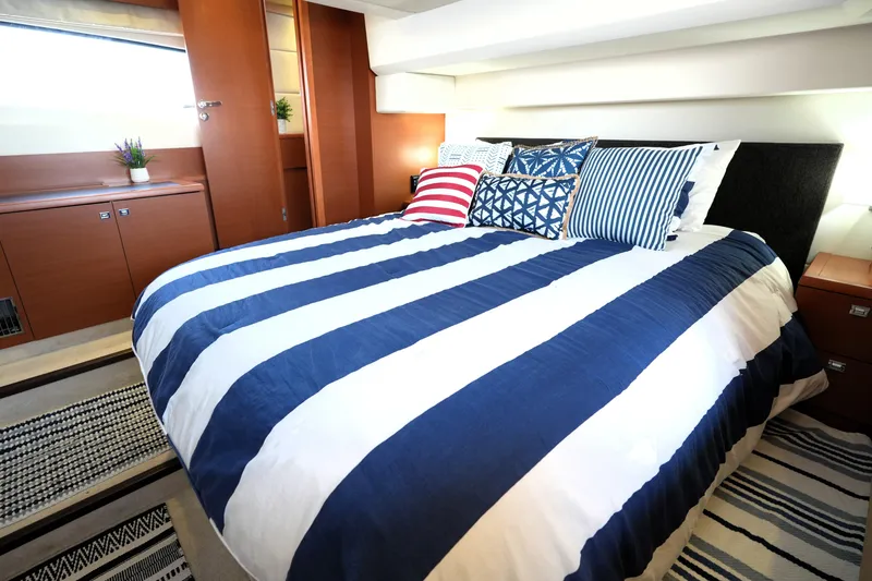 Slide: The Image of Luxurious bedroom interior on a 2013 Prestige 500 yacht with striped bedding and decorative pillows. - 79