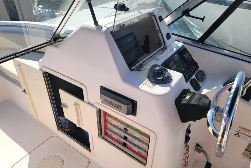 Slide: The Image of 2008 Grady-White Tournament 225 boat dashboard with steering wheel and navigation instruments. - 6