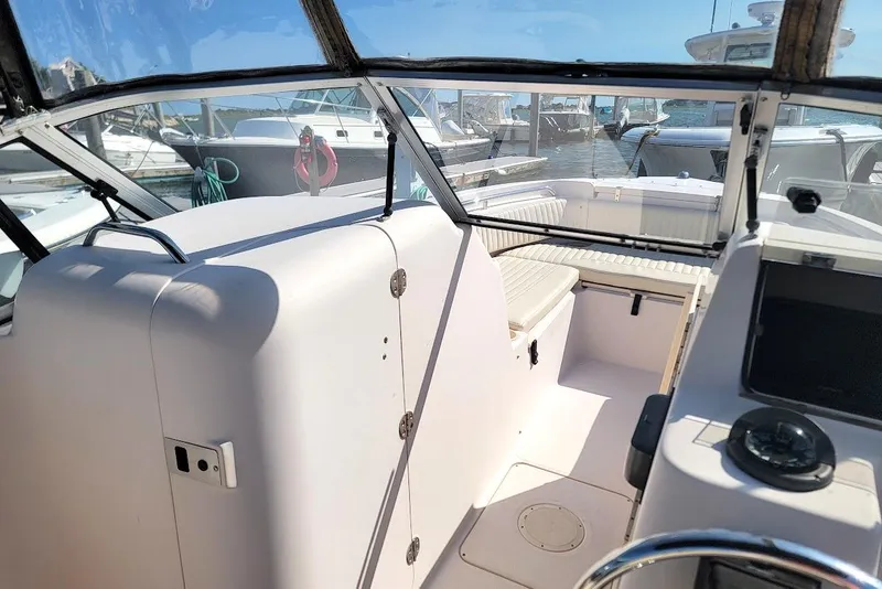 Slide: The Image of 2008 Grady-White Tournament 225 boat interior with seating and helm, docked at marina. - 7