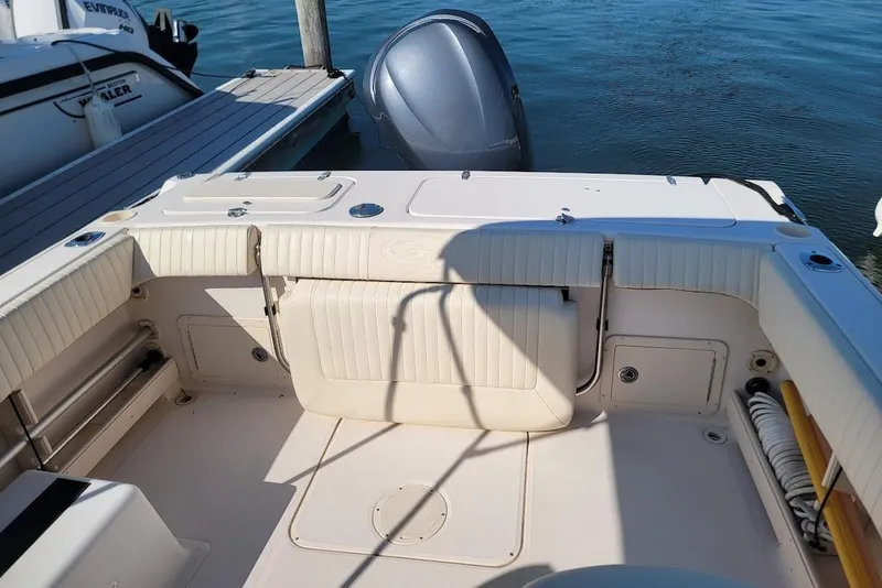 Slide: The Image of 2008 Grady-White Tournament 225 boat interior with seating and motor, docked by water. - 5