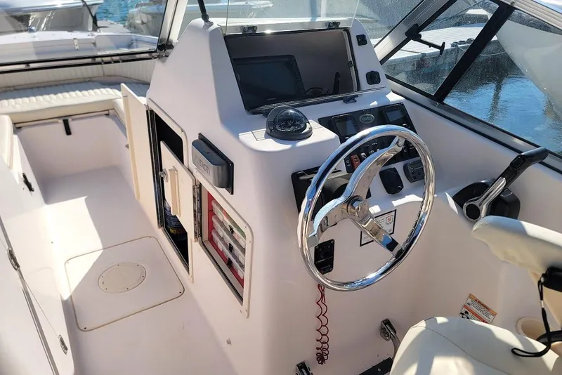 Slide: The Image of 2008 Grady-White Tournament 225 boat cockpit with steering wheel and control panel. - 2