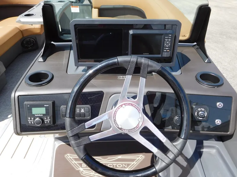 Slide: The Image of The image shows the helm of a Bennington 23 MSB boat with modern instruments and a sleek steering wheel. - 13