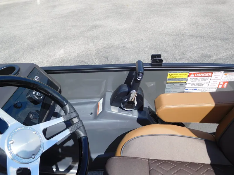 Slide: The Image of The image shows the cockpit of a Bennington 23 MSB boat with a sleek steering wheel and throttle. - 23