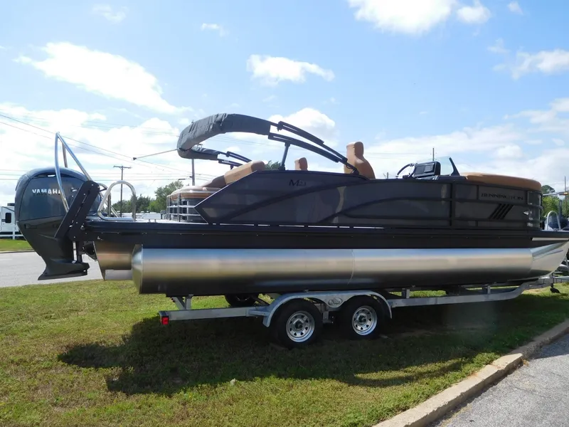 Slide: The Image of A 2026 Bennington 23 MSB pontoon boat is on a trailer on a grassy area. - 6