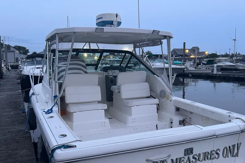 Slide: The Image of 2004 Tiara 2900 boat docked at marina during evening, showcasing spacious seating and sleek design. - 8