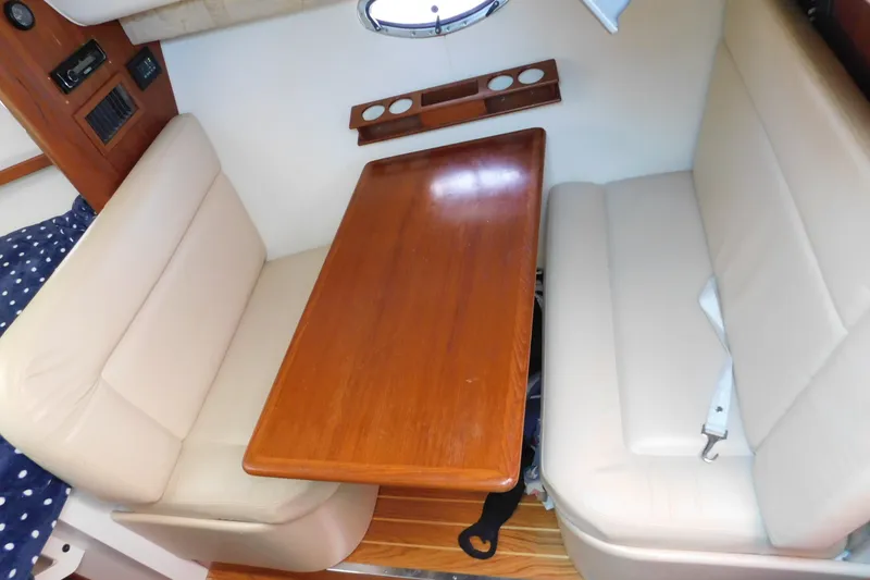 Slide: The Image of Interior of 2004 Tiara Yachts 2900 Open Classic with wooden table and beige seating. - 17