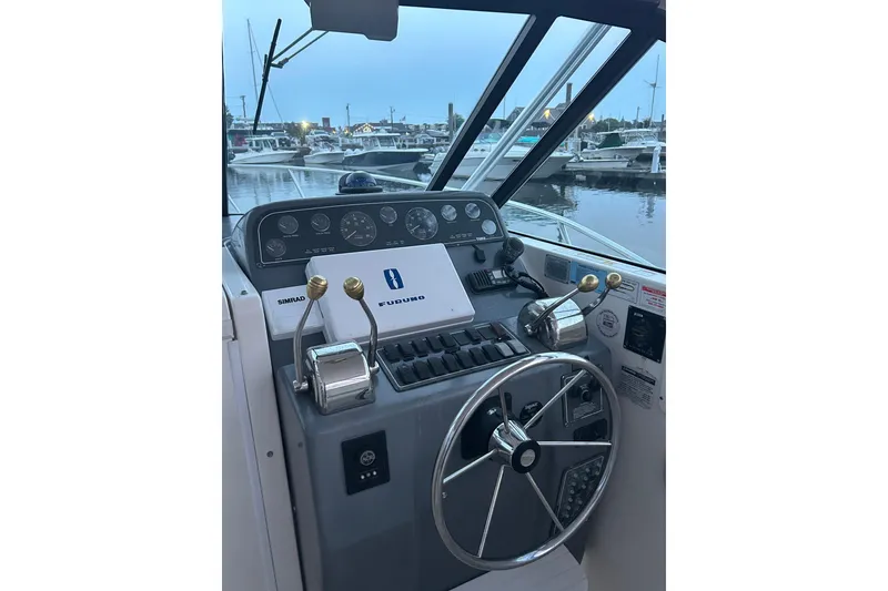 Slide: The Image of Helm of 2004 Tiara 2900 boat with steering wheel and navigation controls at marina. - 11