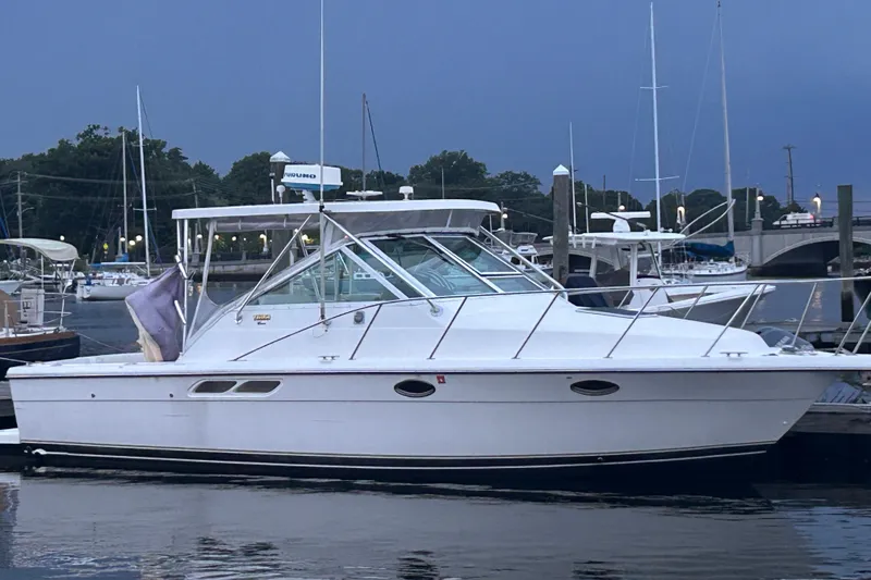 Slide: The Image of 2004 Tiara 2900 boat docked at marina, evening setting with calm waters. - 4