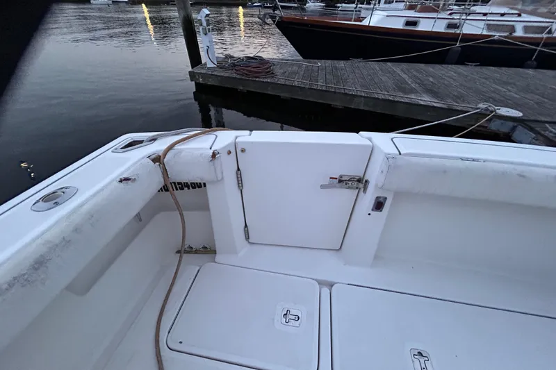 Slide: The Image of 2004 Tiara 2900 boat interior near dock, featuring storage compartments and mooring lines. - 21