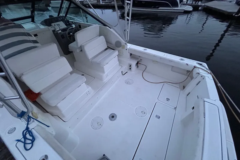 Slide: The Image of 2004 Tiara 2900 boat interior with white seating and control panel at dock. - 7