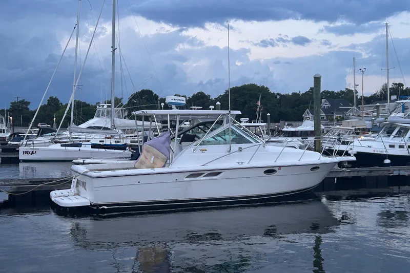 The Image of 2004 Tiara 2900 boat docked at a marina under cloudy skies. - 1