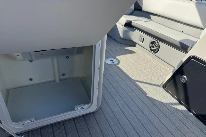 Slide: The Image of 2025 SunCatcher Select 20RC boat interior with storage compartment and seating area. - 13