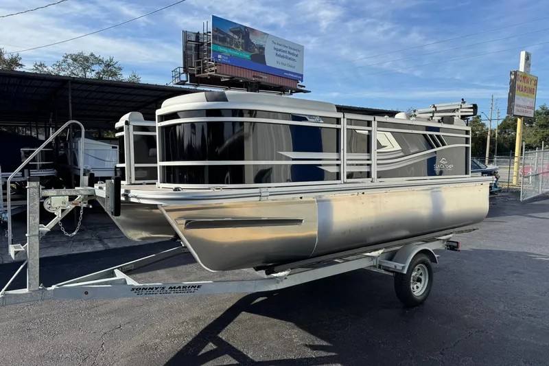 Slide: The Image of 2025 SunCatcher Select 16C pontoon boat on trailer at Sonny's Marine dealership. - 3