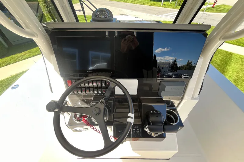 Slide: The Image of 2027 Pursuit S 268 Sport boat dashboard with steering wheel and control panel. - 13