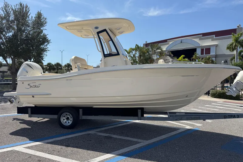 The Image of 2027 Scout 220 XSF boat on trailer, parked outdoors under clear sky. - 0