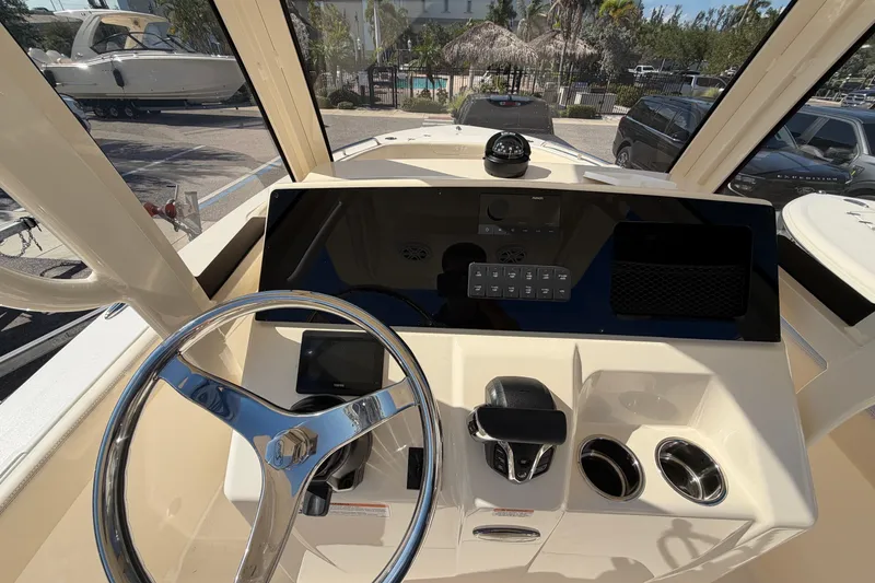 Slide: The Image of 2027 Scout 220 XSF boat dashboard with steering wheel and control panel. - 19