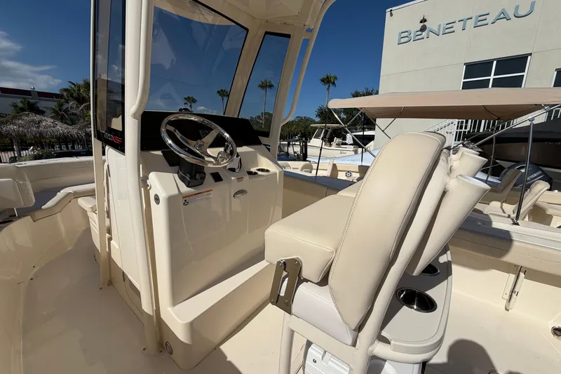 Slide: The Image of 2027 Scout 220 XSF boat interior with steering console and seating, displayed at Beneteau dealership. - 15