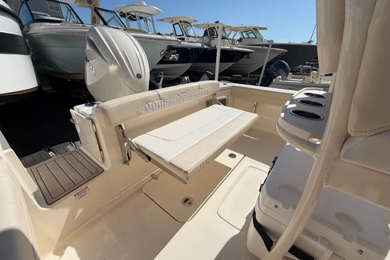 Slide: The Image of 2027 Scout 220 XSF boat interior with seating and Yamaha engine, docked among other boats. - 8