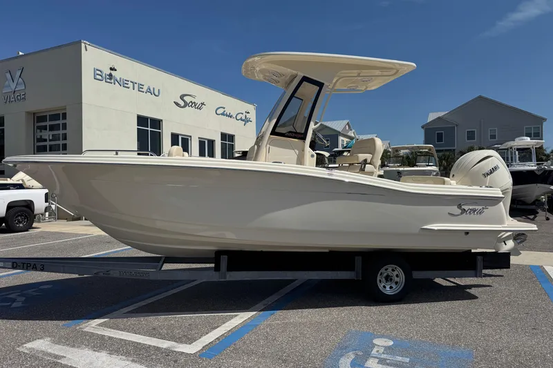 Slide: The Image of 2027 Scout 220 XSF boat on trailer outside dealership, featuring sleek design and Yamaha engine. - 1