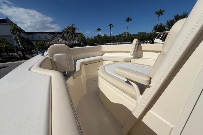 Slide: The Image of 2027 Scout 220 XSF boat interior with beige seating, under a clear blue sky. - 22