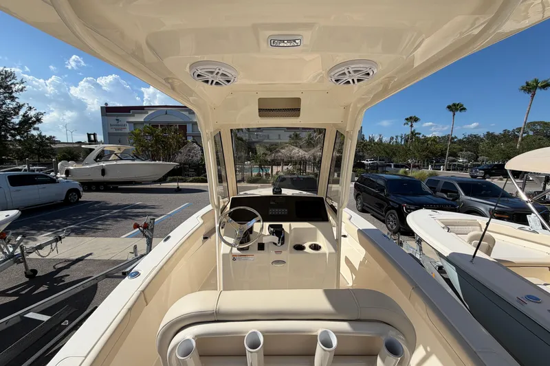 Slide: The Image of 2027 Scout 220 XSF boat interior with steering wheel and console, parked outdoors. - 13