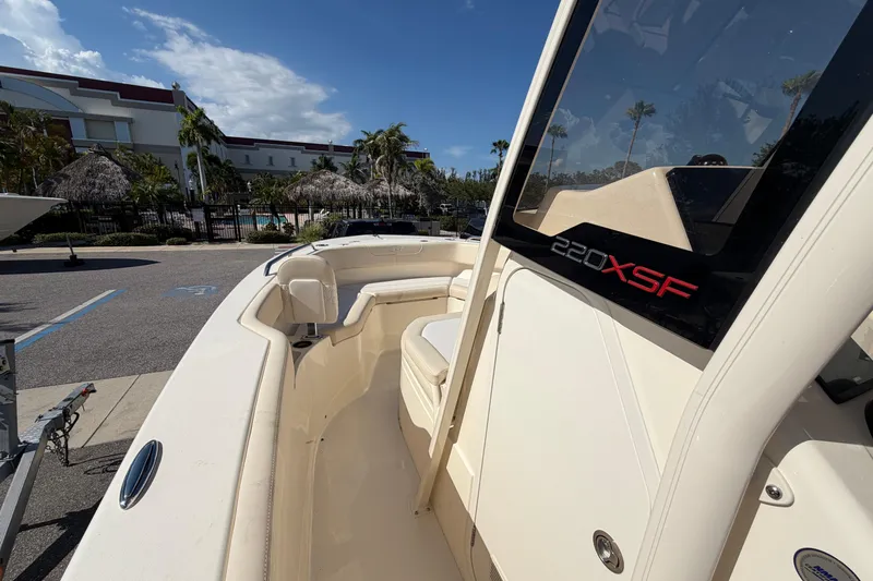 Slide: The Image of 2027 Scout 220 XSF boat docked, showcasing sleek design and spacious seating area. - 21