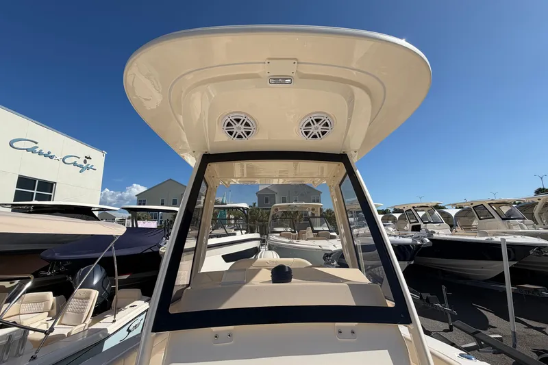 Slide: The Image of 2027 Scout 220 XSF boat with T-top and speakers, displayed at a dealership under clear blue skies. - 29