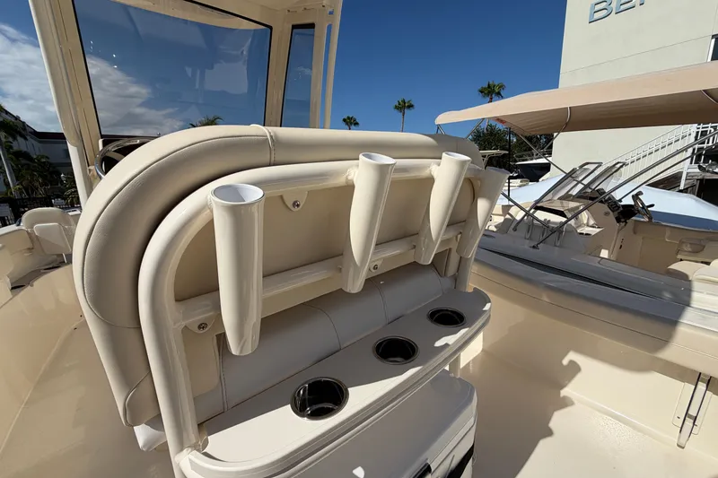Slide: The Image of 2027 Scout 220 XSF boat interior with rod holders and cup holders, under clear blue sky. - 12