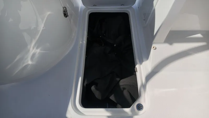 Slide: The Image of An open storage compartment on a boat with black fabric inside. - 18
