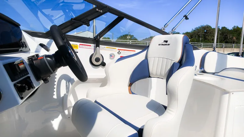 Slide: The Image of The image shows the helm of a Stingray 231 DC boat with a sleek white seat. - 22
