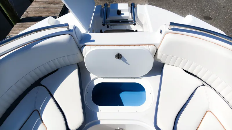 Slide: The Image of The image shows the bow area of a Stingray 231 DC boat with white upholstery and storage. - 21