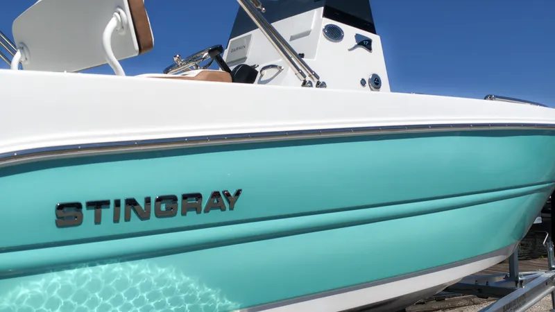 Slide: The Image of A turquoise Stingray 173 CC from 2027 with a white deck and helm console. - 15